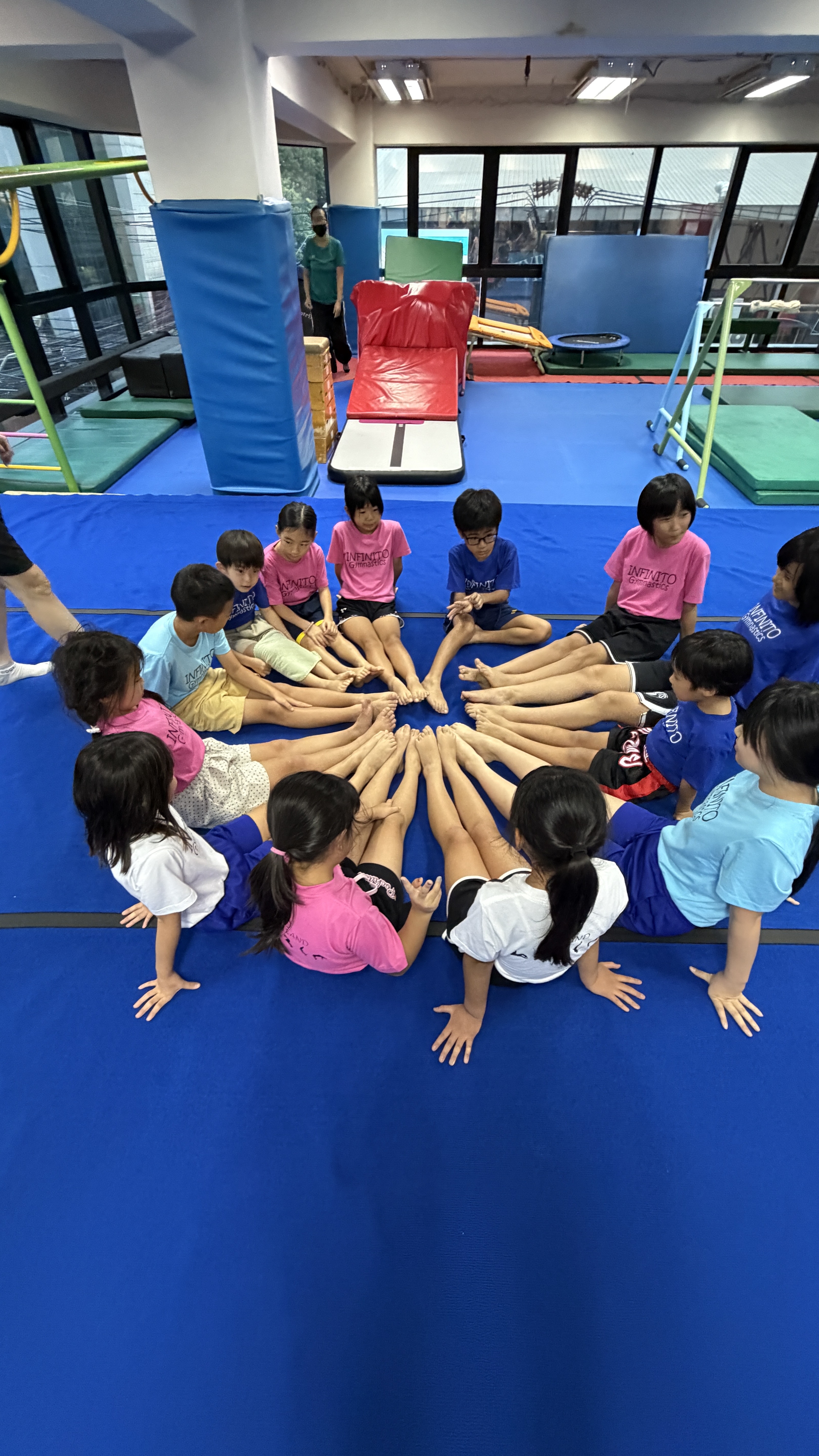 INFINITO gymnastics students group circle